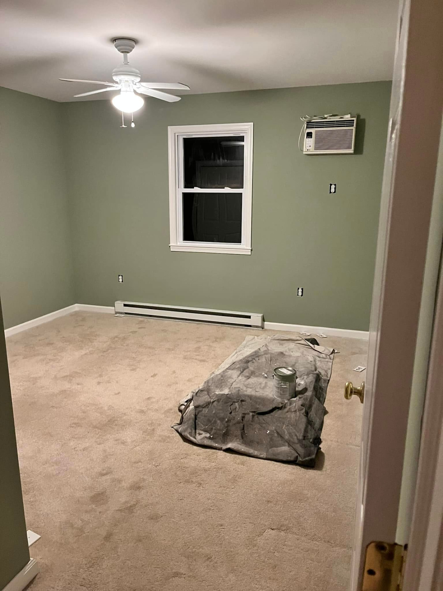 Same bedroom after painting in a soft sage green with clean white trim